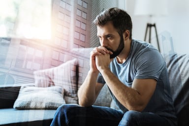 seated man with serious expression resting head on hands_GettyImages-909574170