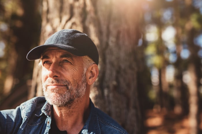 Closeup of older man in front of tree