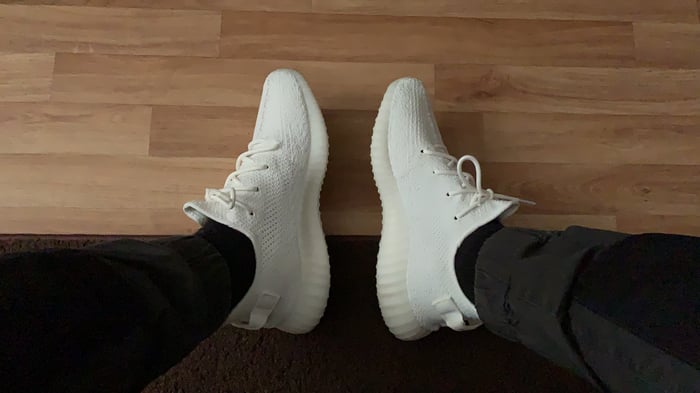 A pair of white Adidias Yeezy Boost 350 V2 sneakers