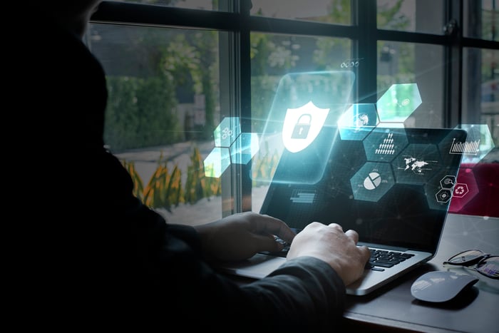 A man uses cybersecurity software on a notebook computer.