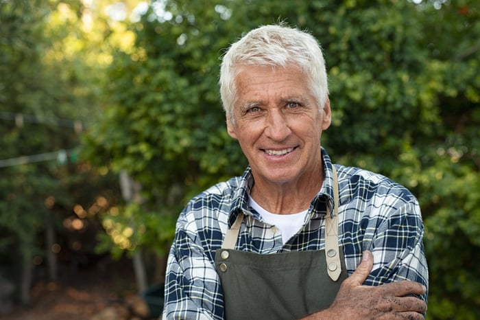 Smiling older man in apron outdoors