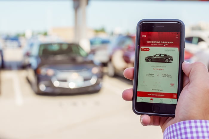 Customer securing Avis car rental with a smartphone.