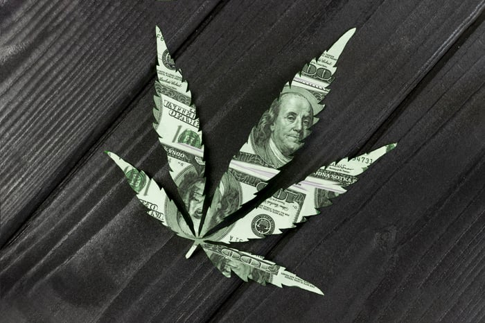 Hundred dollar bill cut into the shape of a marijuana leaf.