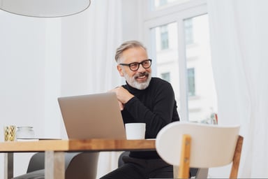 Smiling older man at laptop_GettyImages-1073253576
