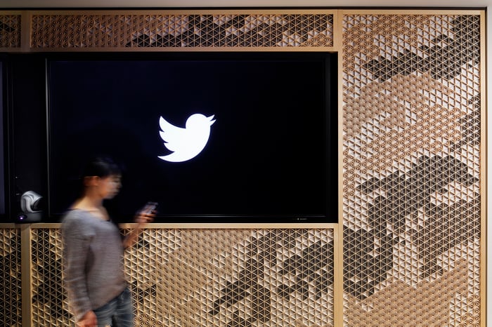Woman walking by a Twitter logo