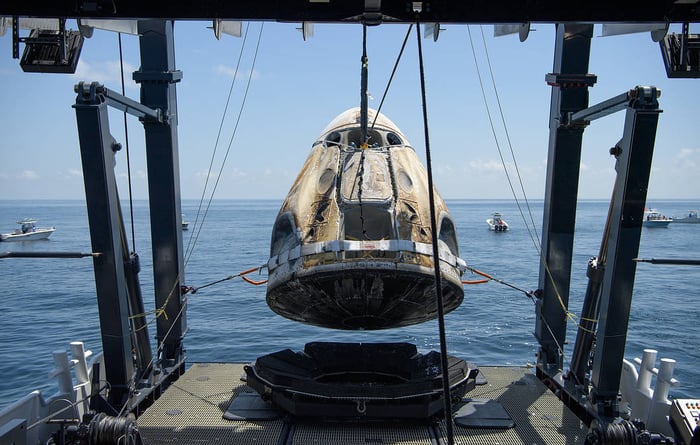 SpaceX Crew Dragon Endeavour being lifted aboard recovery ship.