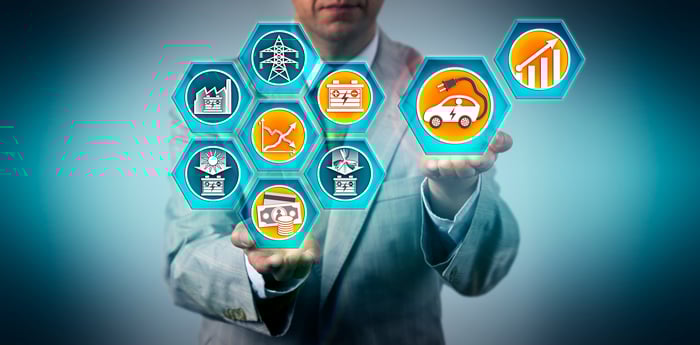 A person in a suit holding several renewable energy icons.