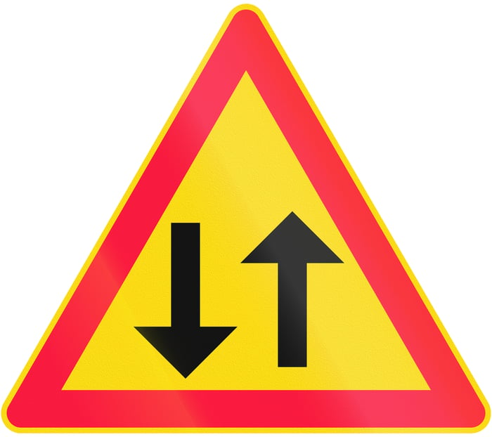 Caution sign with an up and a down arrow inside a red border on a yellow background