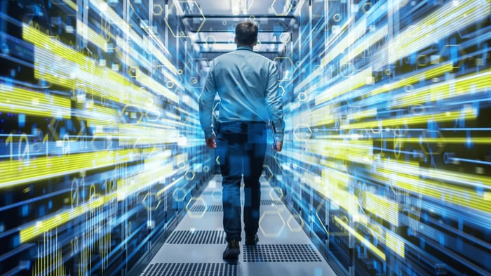 An IT professional walks into a data center with a visual overlay of charts and numbers.