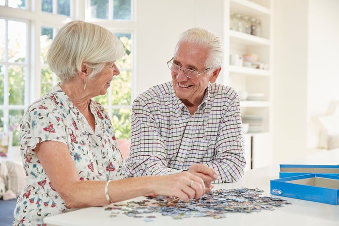 Older man and woman at table doing a puzzle