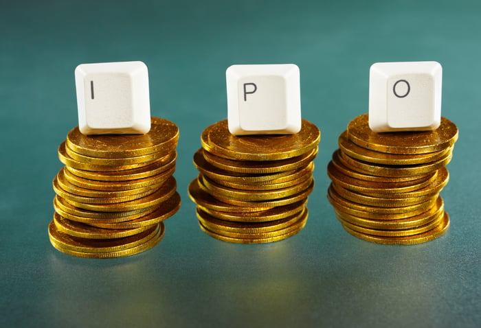 Three stacks of coins are aligned in a row, each topped with keyboard letters spelling IPO.