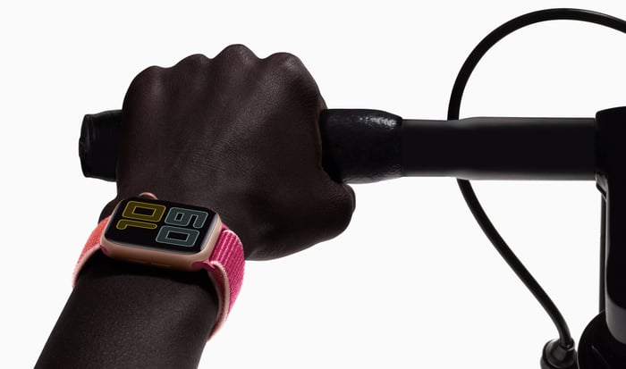 Close-up of a hand gripping a handlebar, with an Apple Watch on the person's wrist