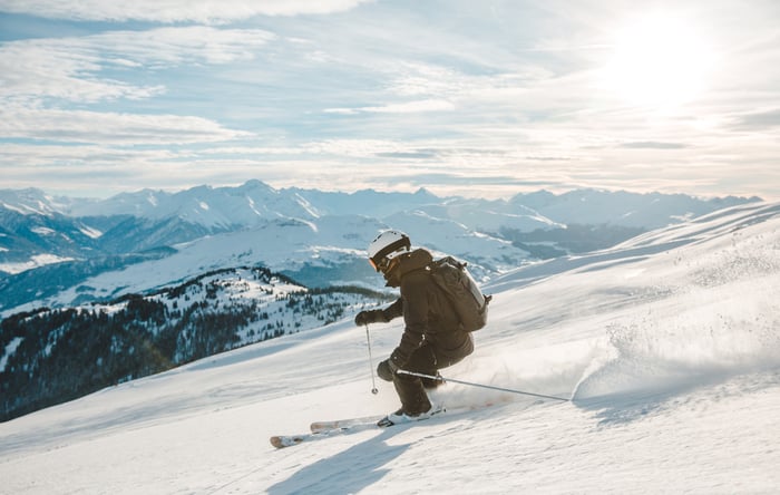 A skiier skis down a mountain.