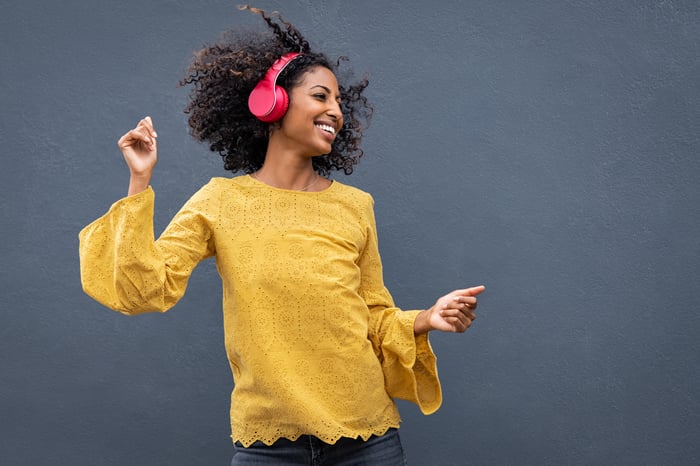 woman dancing and listening to music with headphones