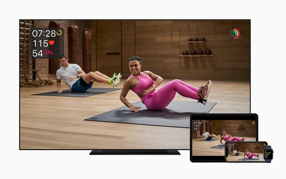 A TV, iPad, iPhone, and Apple Watch displaying a woman and man working out.