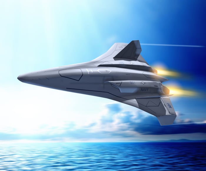 An illustration of a high-tech fighter flying low over the ocean.