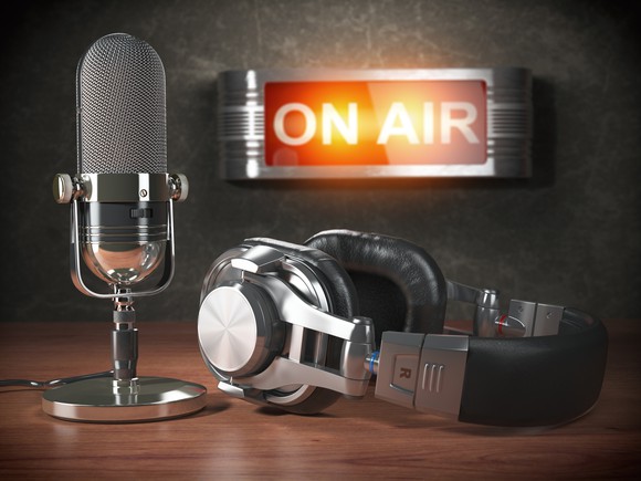 A microphone and headphones next to a lit sign saying on air.