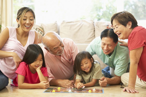 An extended family from children to grandparents playing a board game.