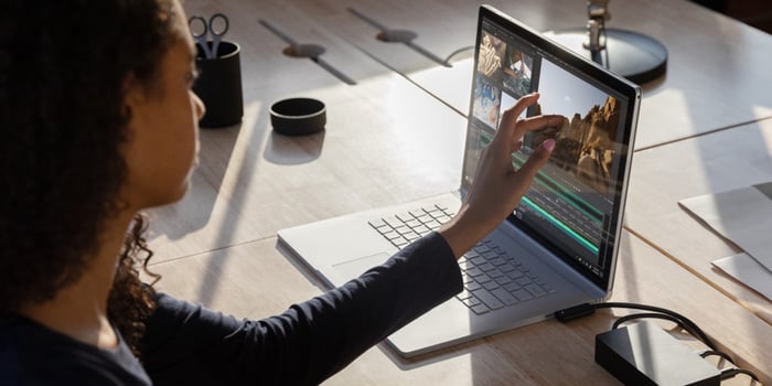 Woman touching screen of laptop