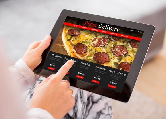 Someone holding a tablet ordering pizza online.