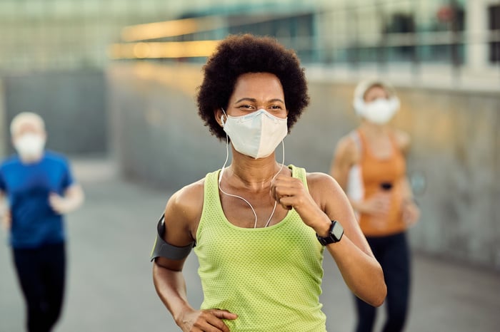 Several people running while wearing face coverings.