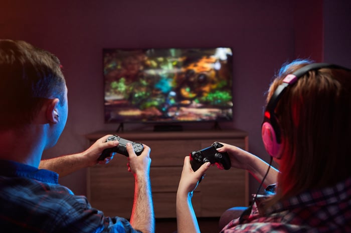 People playing video games while sitting on a couch