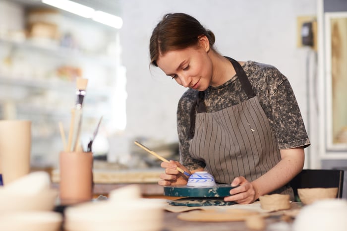 A woman painting pottery.