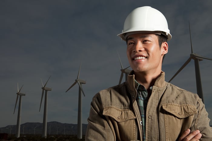 A man in front of wind turbines.