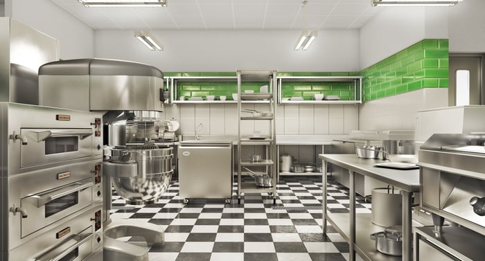 Stainless steel commercial kitchen with a black and white tile floor