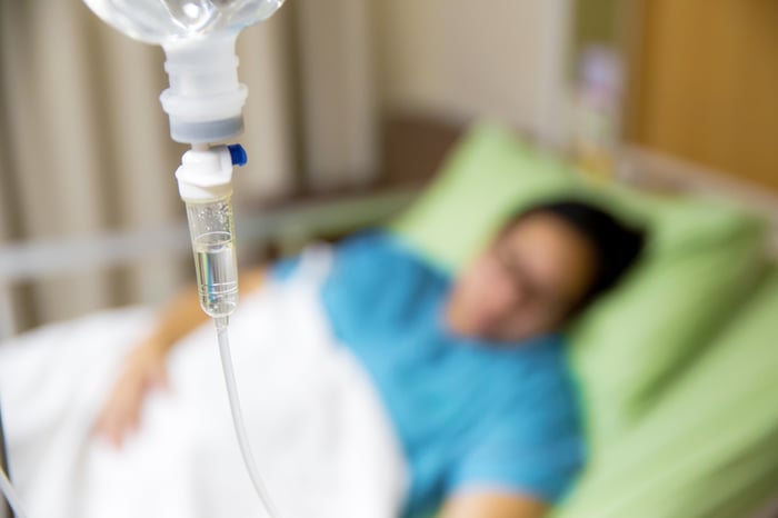 Hospital patient with an IV drip in a hospital bed.