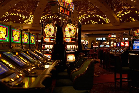 A casino empty of customers, with slot machines and other devices lit up.