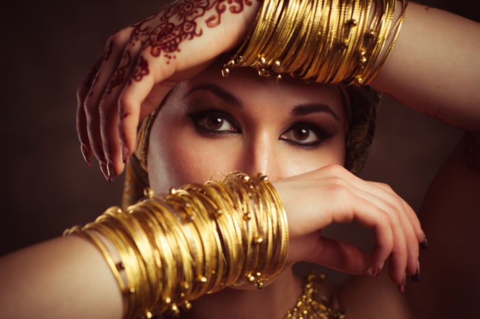 A woman holding up her arms, which are adorned with gold bangles