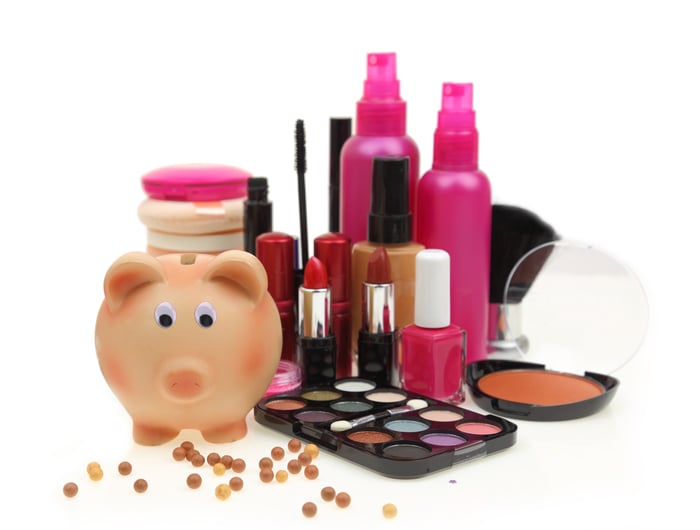 Lipstick and other makeup next to a piggy bank