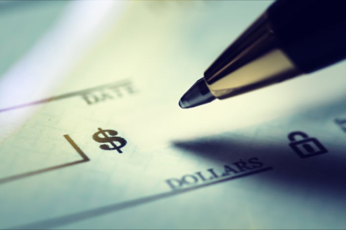 A pen hovering over a blank check.