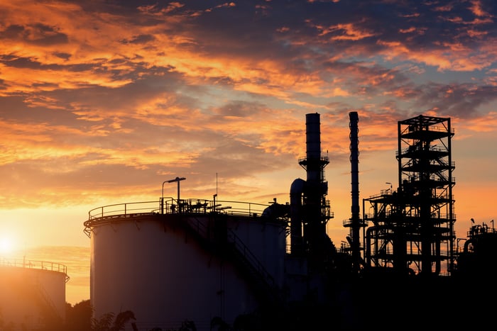 A storage tank with the sun rising in the background.