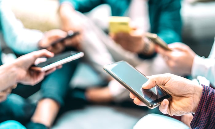 Numerous people using smartphones.