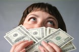 woman smelling 100 bills --GettyImages-101749466