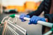 Shopping cart being pushed by gloved hands