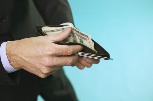 Person thumbing through wallet.