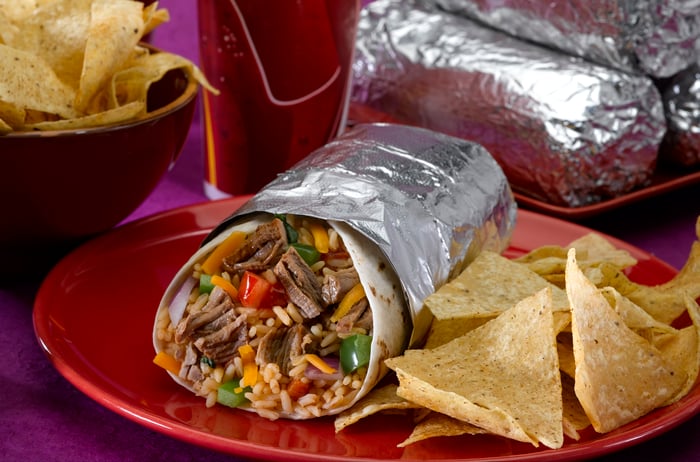 A burrito with a side of chips. 