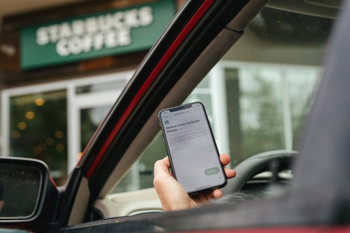 Starbucks store facade seen from a car occupied by person using the company's mobile app.