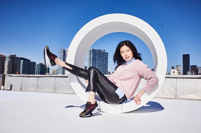 Woman sitting in a tube, showing off sneakers