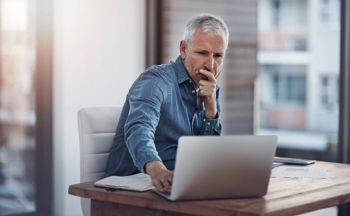 Man with serious expression looking at laptop