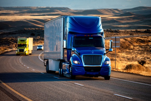 Long-haul freight trucks on a highway.