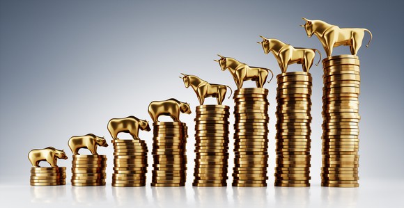 Bull and bear figurines on top of ascending stacks of coins.