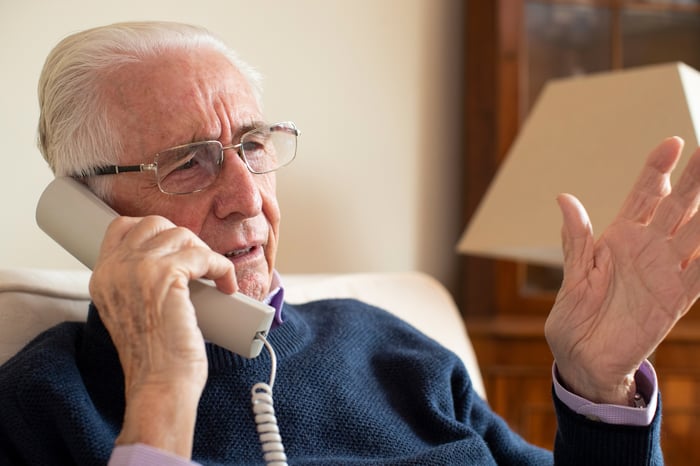 Older man with concerned expression talking on phone