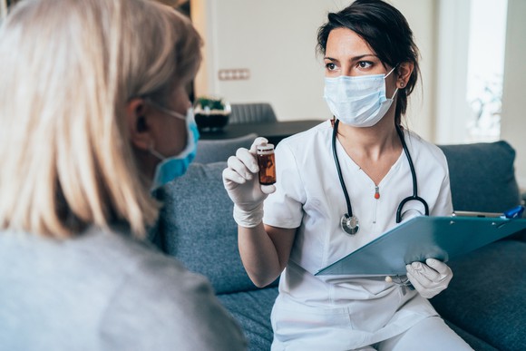 Doctor sitting on couch and discussing presciption with patient