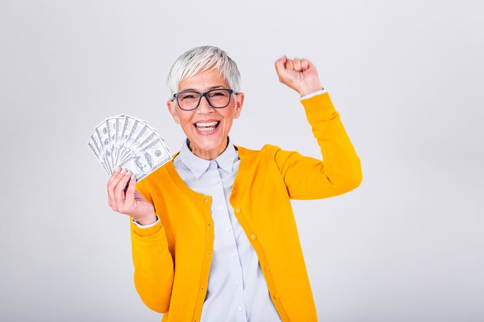 Happy senior woman holding hundred dollar bills