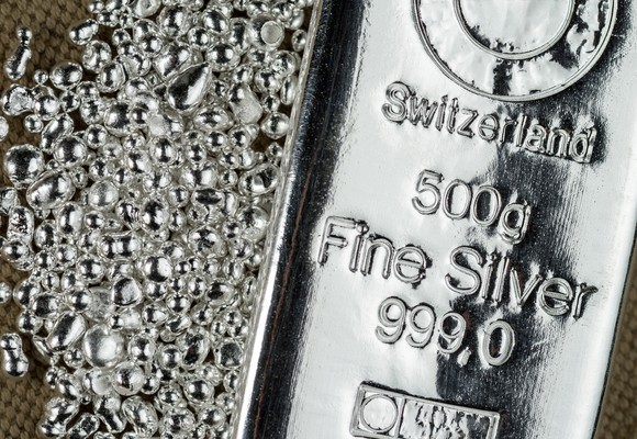 A silver bar beside a pile of silver grains.