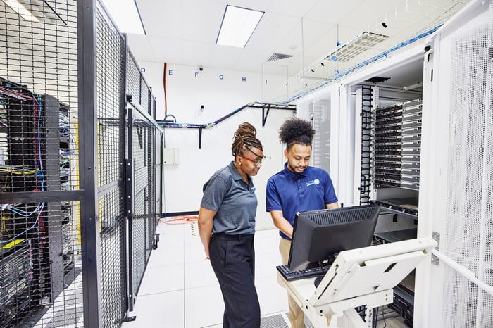 Information technology professionals configuring servers in a data center.